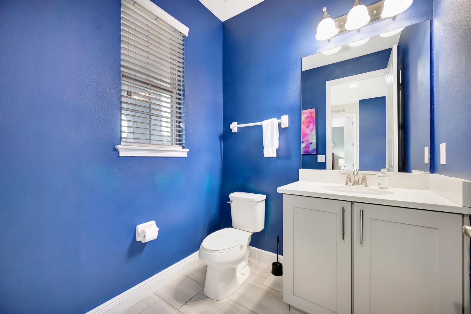 Step into your private bathroom, where vibrant blue walls create a refreshing, energizing atmosphere. Clean white fixtures and modern finishes ensure your comfort during your stay.