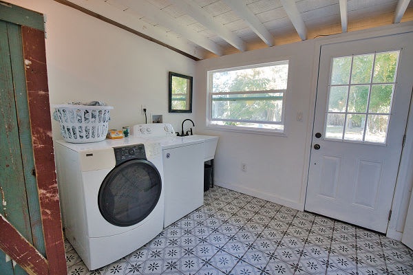 Your laundry area offers everything you need—a washer, deep sink, and peaceful natural light streaming through the windows. Stylish floors and vaulted ceilings make even chores feel more enjoyable.
