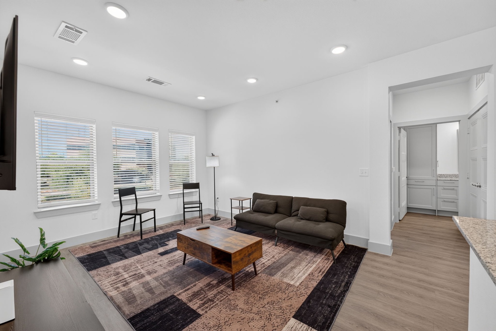 Settle into your bright, modern living space where clean lines and warm wood tones create the perfect spot to unwind after a day exploring the area.
