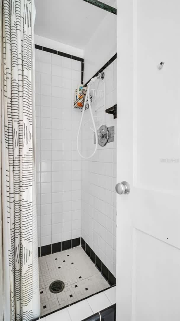 Step into your private walk-in shower with classic white subway tiles and retro black accents. The refreshing spray awaits you after a day of adventure.