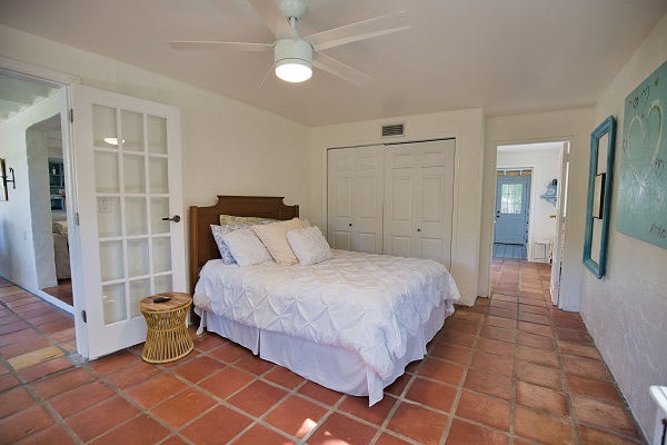 Step into your peaceful retreat, where warm terracotta tiles and a ceiling fan create a serene, coastal-inspired space. Rest easy on the plush bed and enjoy gentle breezes that keep you comfortable throughout your stay.