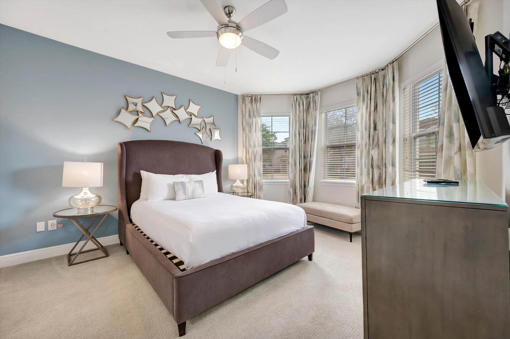 Sink into your plush, inviting bed with crisp white linens after a full day of adventure. Natural light filters through curtained windows as you relax on the bench seating, creating your peaceful retreat with soft, soothing tones and modern touches.