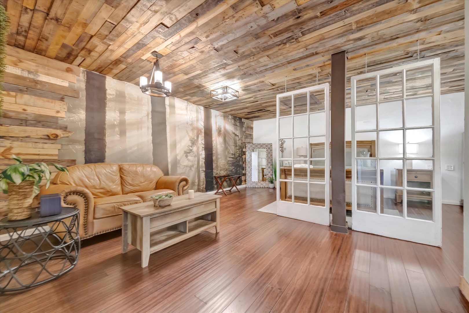 Relax in your spacious living room where rustic wood ceilings and warm hardwood floors create a cozy, inviting retreat after your adventures.