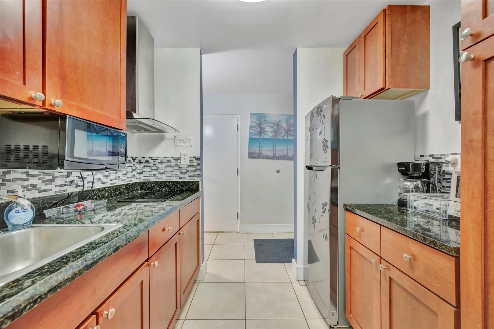 Your fully equipped galley kitchen features granite countertops, warm wood cabinetry, and modern appliances—everything you need to whip up a quick snack or prepare a delicious home-cooked meal during your stay.