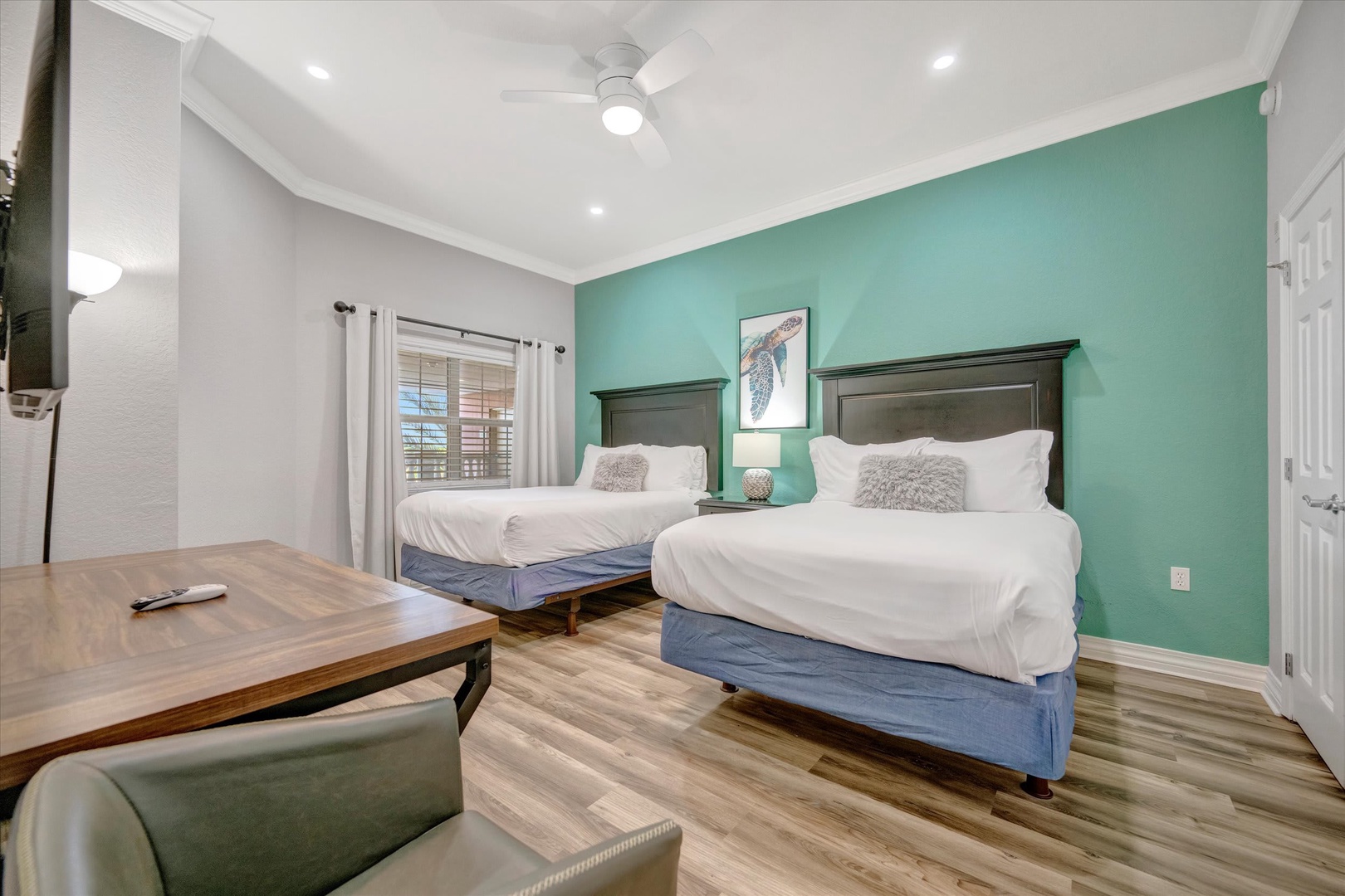 Sink into crisp, plush bedding after a day of adventure. This spacious bedroom offers two inviting queen beds with a calming coastal vibe, ensuring your group sleeps soundly in style and comfort.