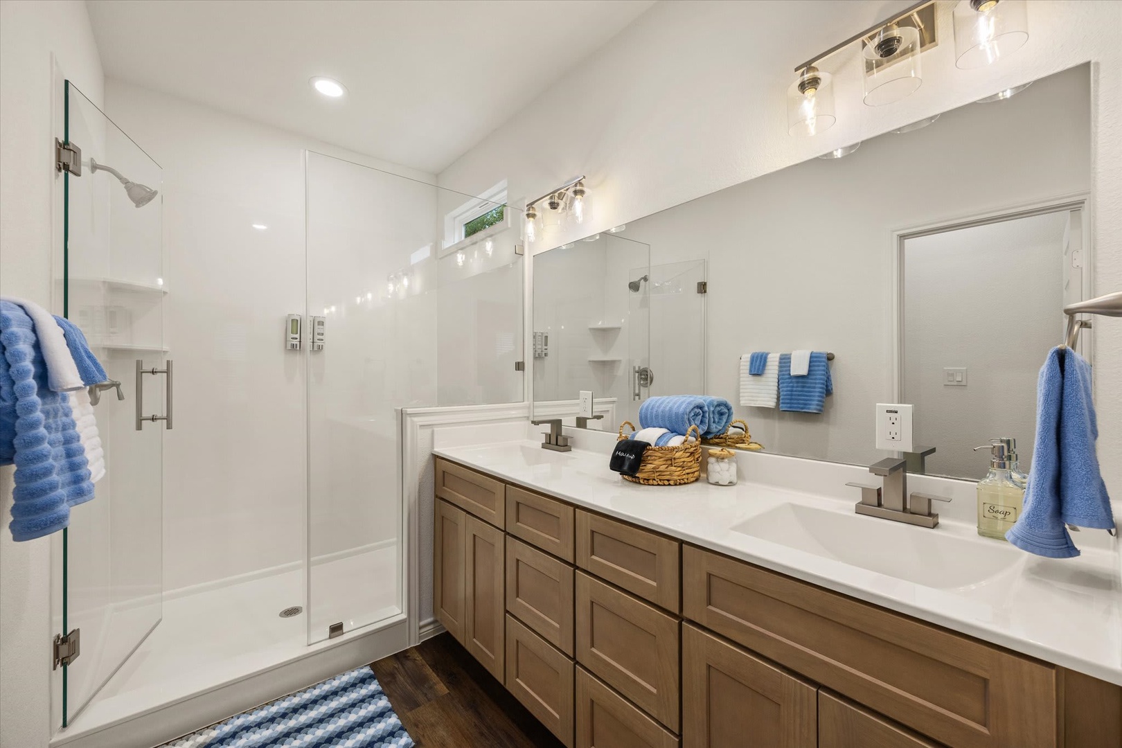 Step into your spa-like ensuite, where crisp white tile and warm wood cabinetry create a serene retreat. The dual vanity and spacious walk-in shower invite you to unwind after your adventures.