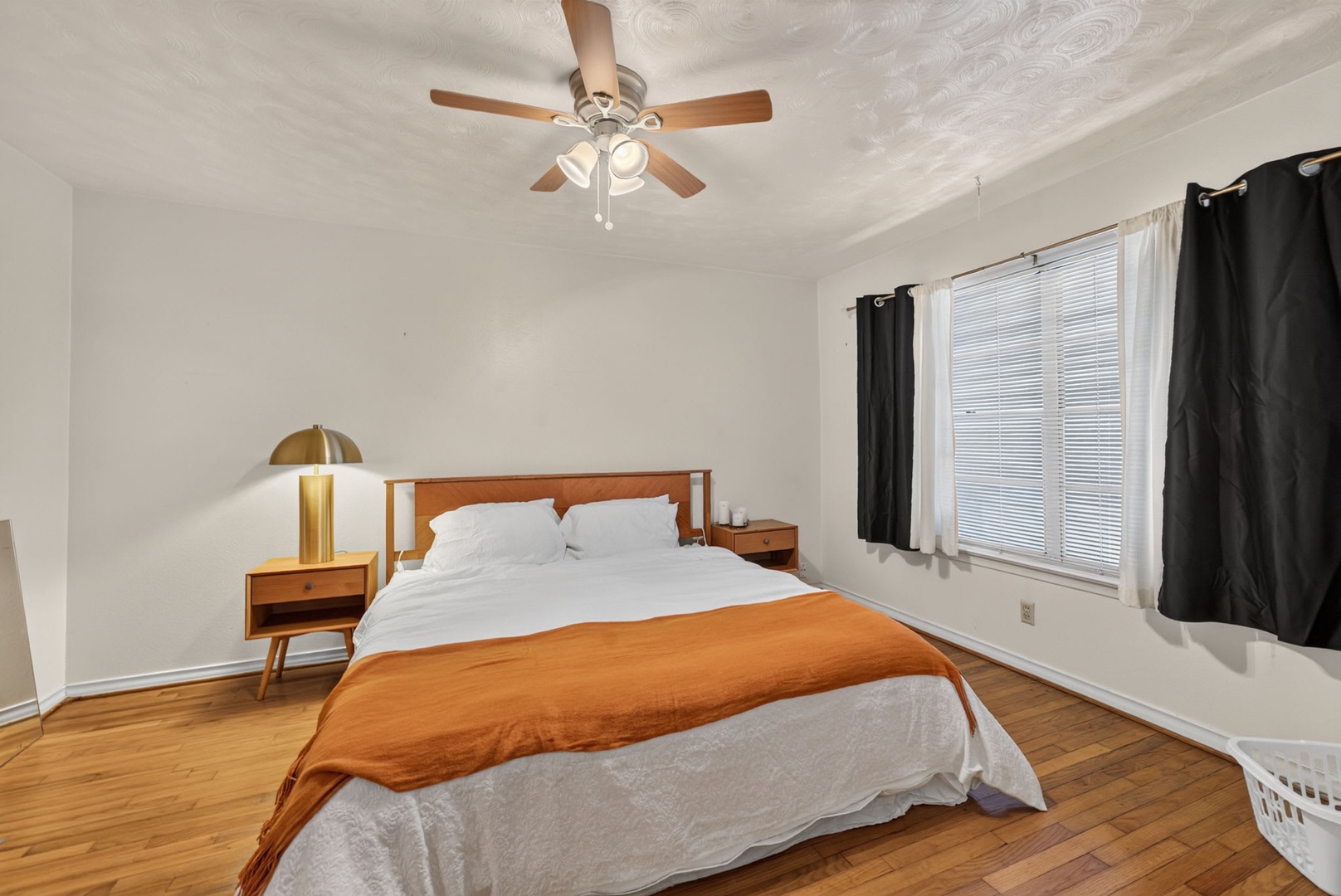 Unwind in your serene bedroom, where warm wood tones and soft linens invite restful nights beneath the gentle hum of the ceiling fan.