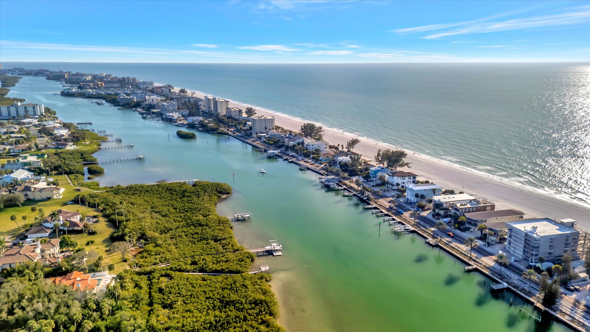 An aerial view of the beachfront area showcasing the coastal community, waterways, and sandy shoreline.