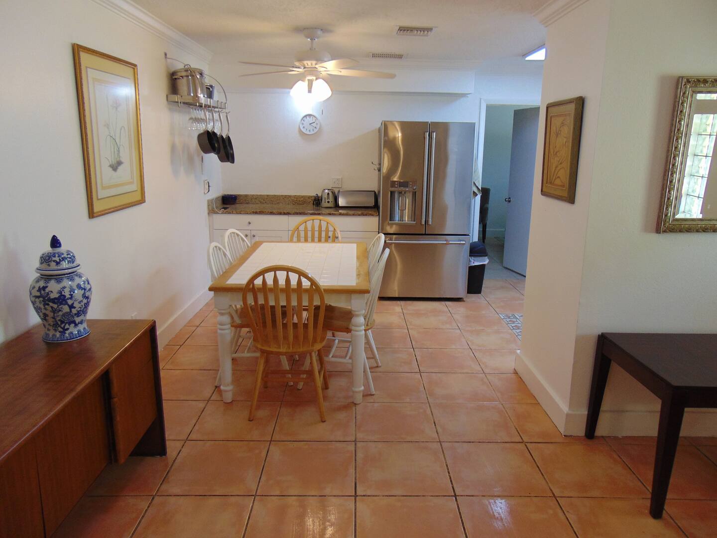 Spacious dining area flows seamlessly into a fully-equipped kitchen with warm terracotta tiles and stainless steel appliances—the perfect space for cooking, gathering, and making memories.