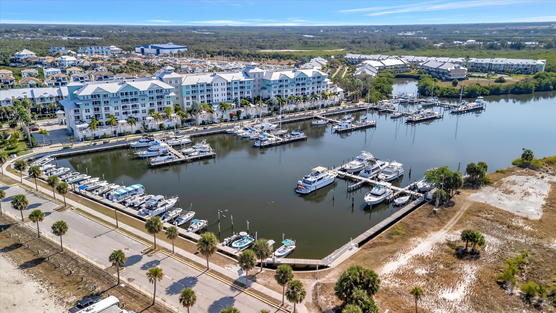 Waterfront property featuring a marina with boat slips, nestled alongside a peaceful inlet and surrounded by coastal Florida scenery.