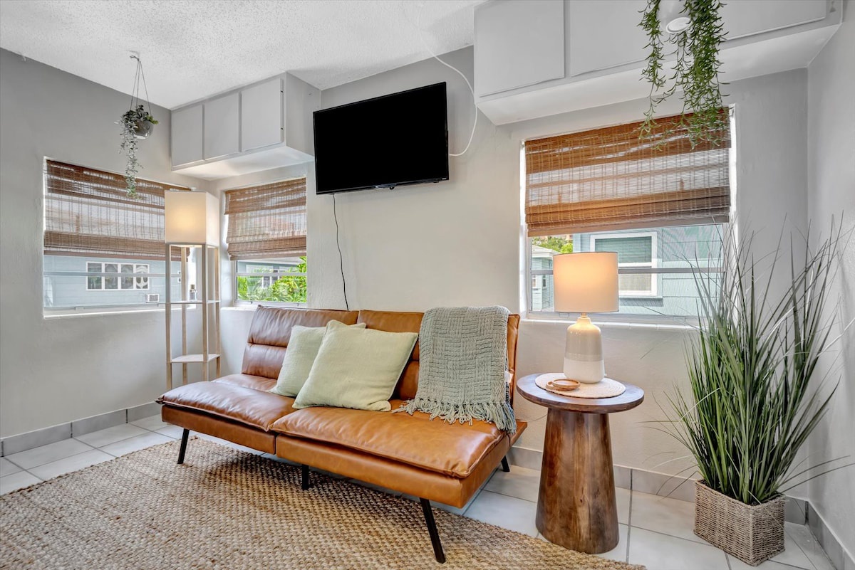 Sink into the stylish caramel leather sofa and unwind in your light-filled retreat, where natural textures and hanging greenery create a calm, welcoming atmosphere.