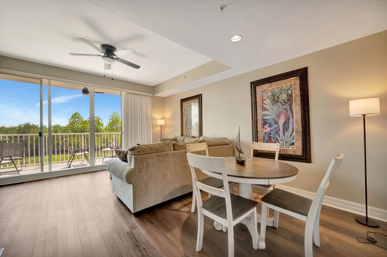 Relax in your bright, open living space with natural light streaming through floor-to-ceiling windows. Unwind on the plush sofa or step out to your private balcony to soak in the peaceful treetop views.