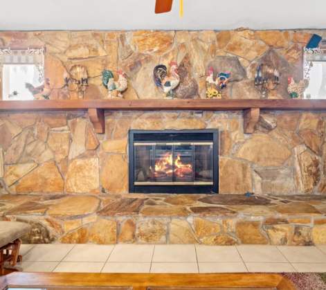 Gather around a stunning floor-to-ceiling stone fireplace that anchors your living space with rustic warmth and mountain charm.
