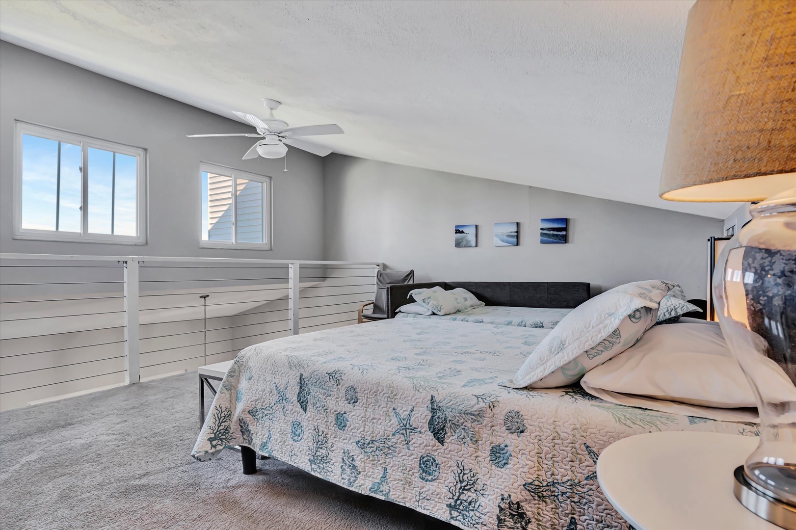Drift off under the soft glow of ambient lighting in this calming loft bedroom, where coastal touches and vaulted ceilings create your private retreat.