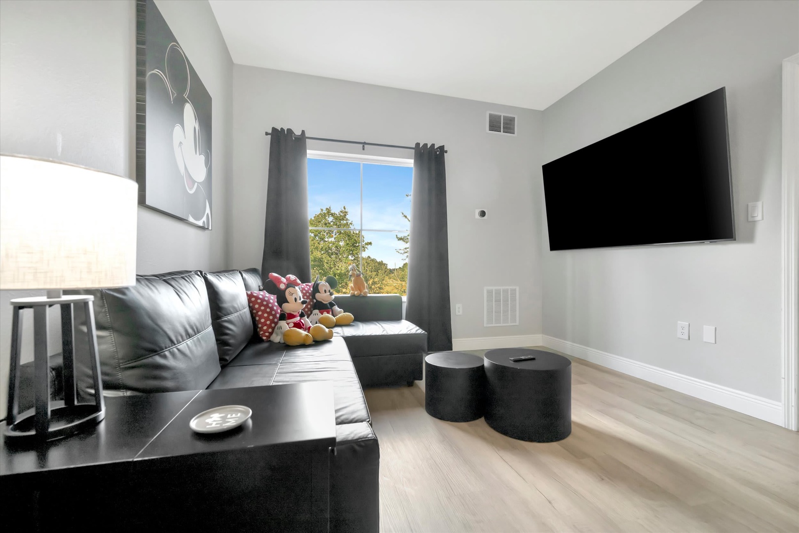 Settle into the cozy living area with your family, where playful décor and soft seating invite laughter and relaxation. Natural light pours through the window, brightening your vacation moments together.