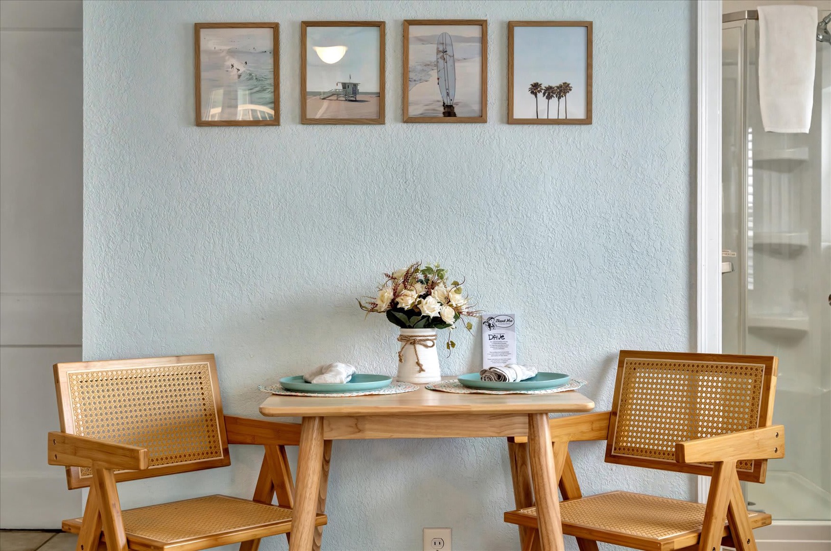 Settle in for your morning coffee at this charming bistro-style table set with calming coastal touches and beach-inspired artwork that captures the relaxed vibe of your getaway.