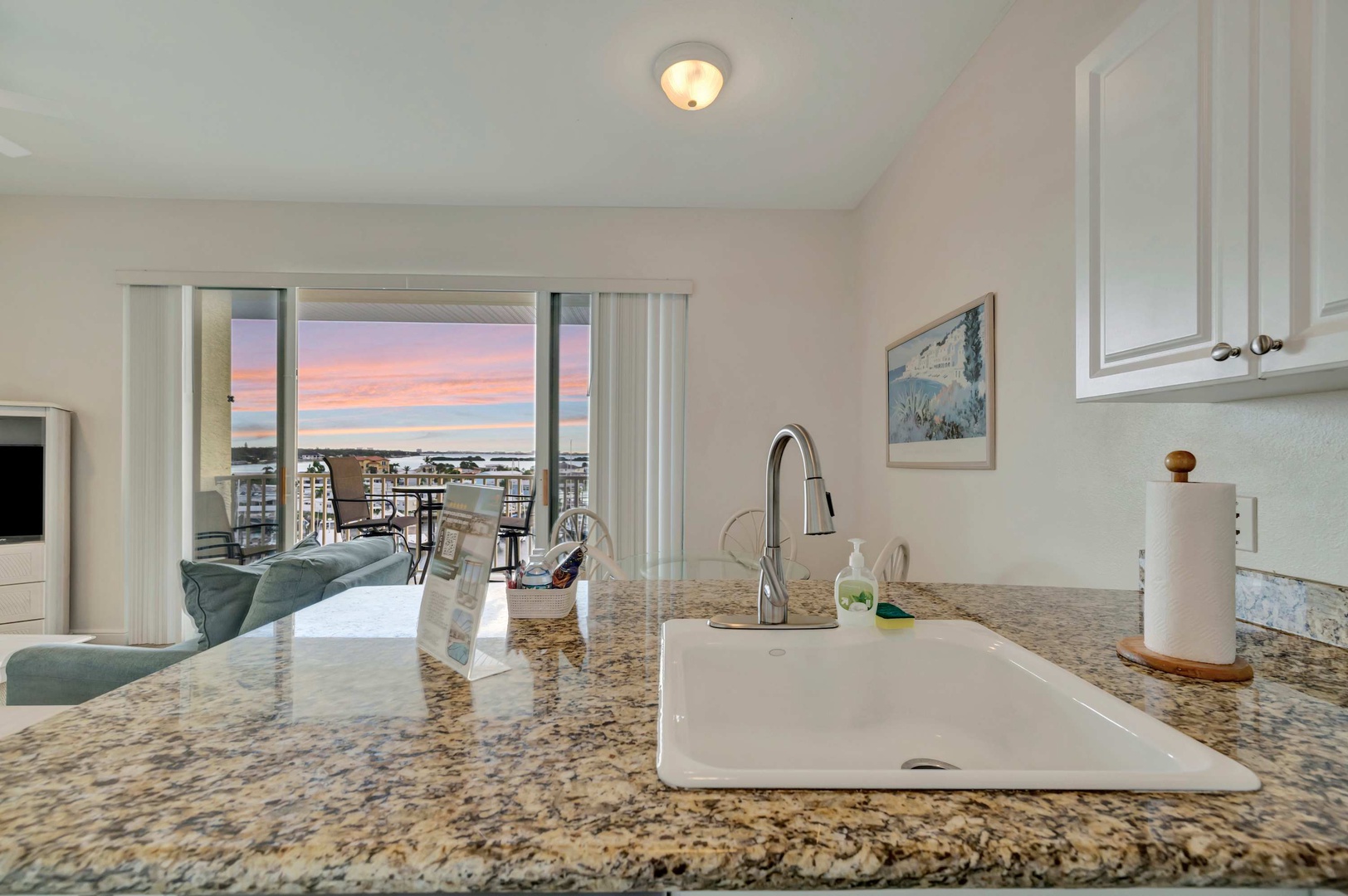 Enjoy preparing meals at your sleek granite countertop while gazing at the stunning waterfront sunset through the open living space. The kitchen flows seamlessly to your private balcony, making every moment feel special.