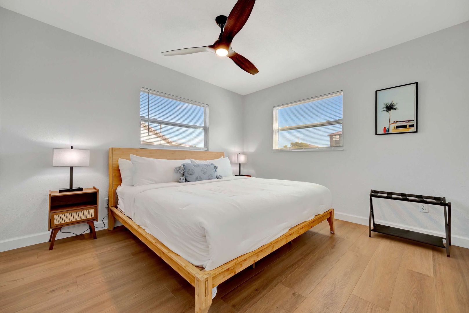 Settle into crisp white linens and wake refreshed under soft ceiling fan breezes—your serene bedroom retreat awaits with natural light and coastal style.