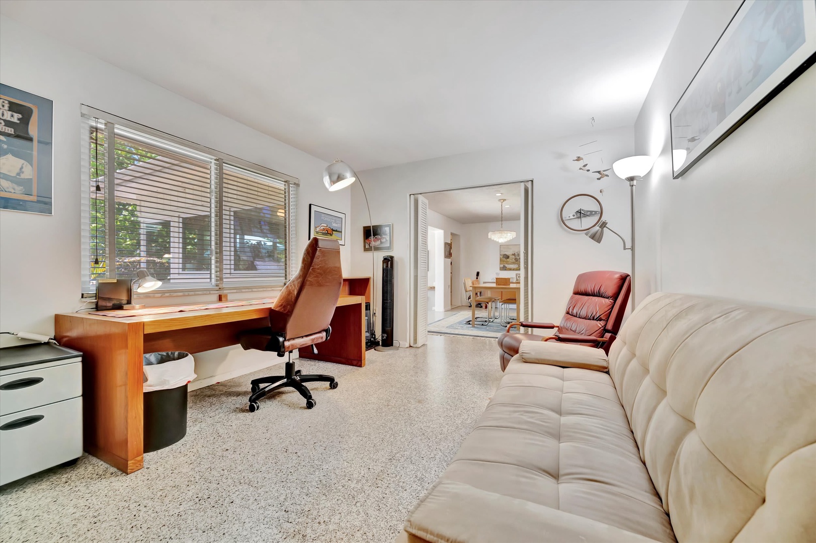 Settle into this stylish living area with comfortable seating and a spacious workspace. Bright windows invite natural light while you relax or get work done in your own tranquil retreat.