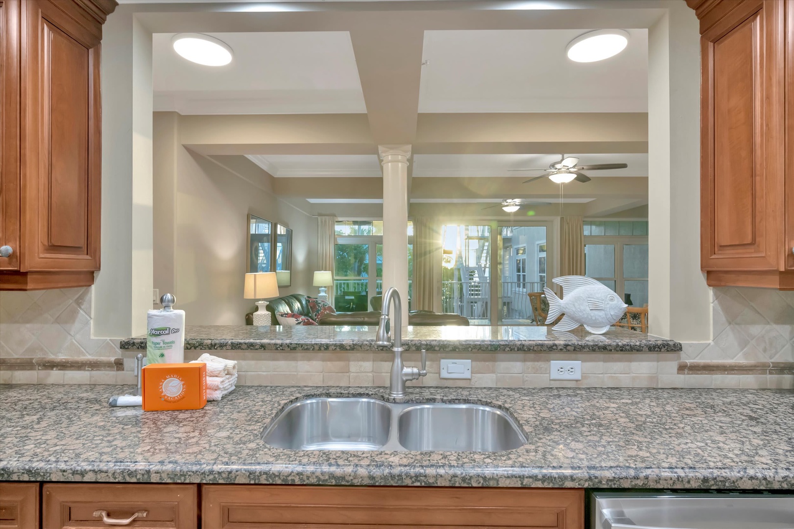 Your gourmet kitchen flows seamlessly into the living spaces, with gleaming granite countertops and a perfect view of the coastal-inspired decor beyond.