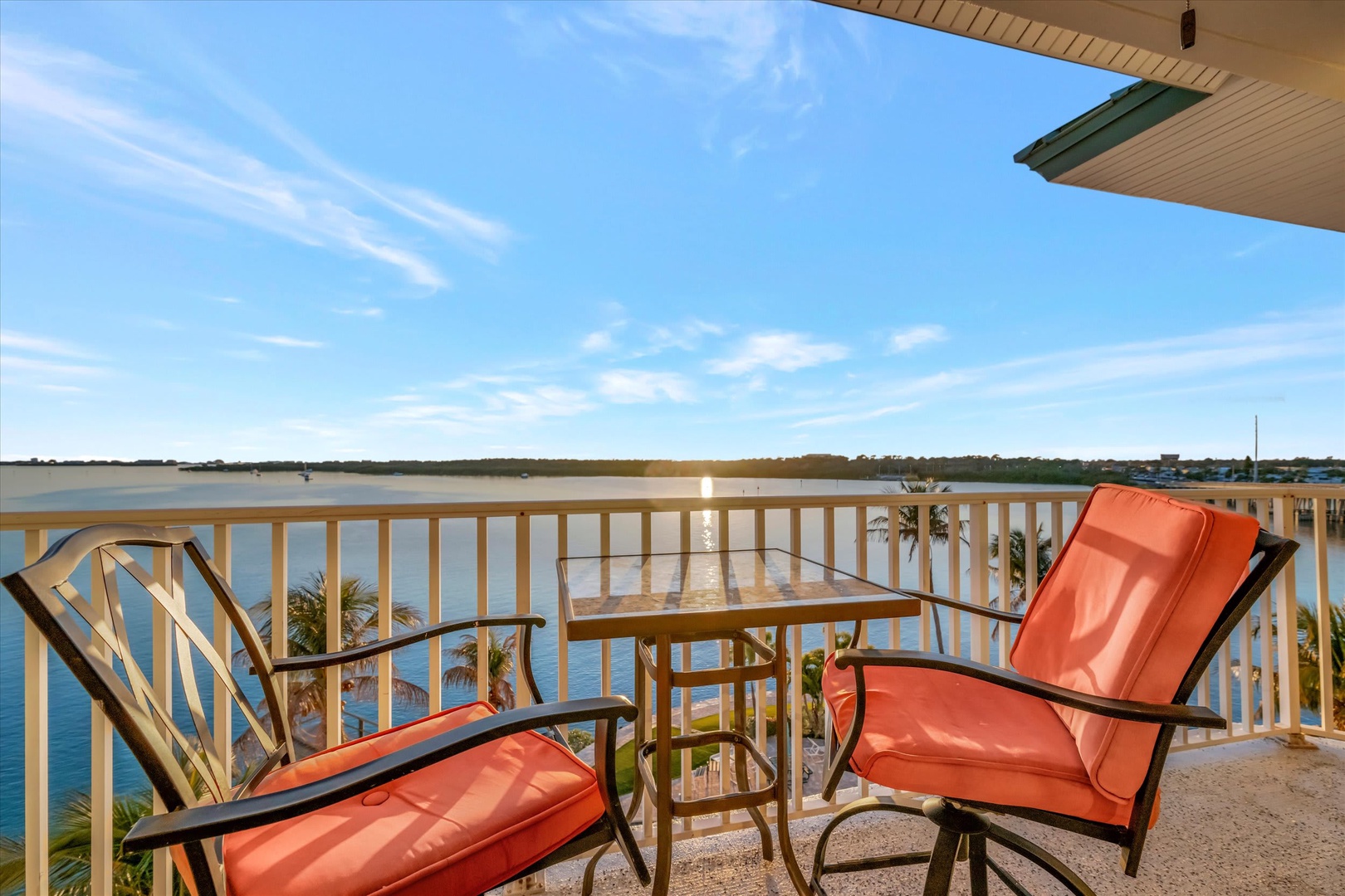 Private balcony overlooking tranquil water with vibrant orange seating—your perfect spot to unwind with morning coffee or watch the sunset reflect across the lake.