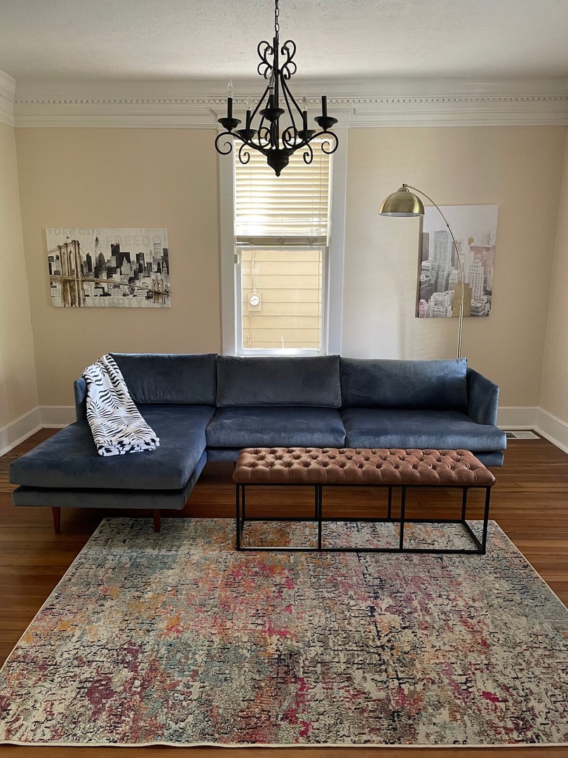 Sink into plush velvet seating where elegant lighting and warm hardwood floors create your perfect space to unwind after exploring the city.