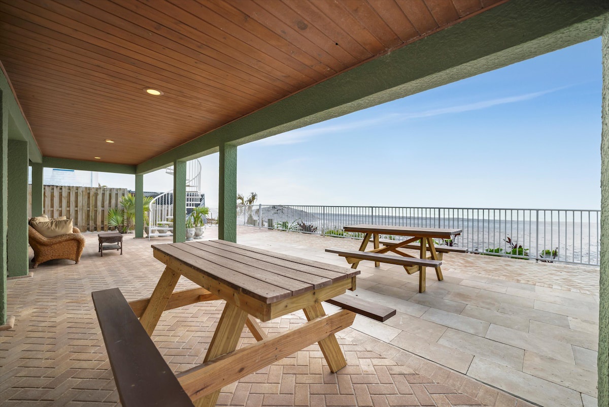 Step outside to your expansive covered patio, where sunny skies meet the horizon and picnic tables beckon you to dine with an ocean breeze as your backdrop.
