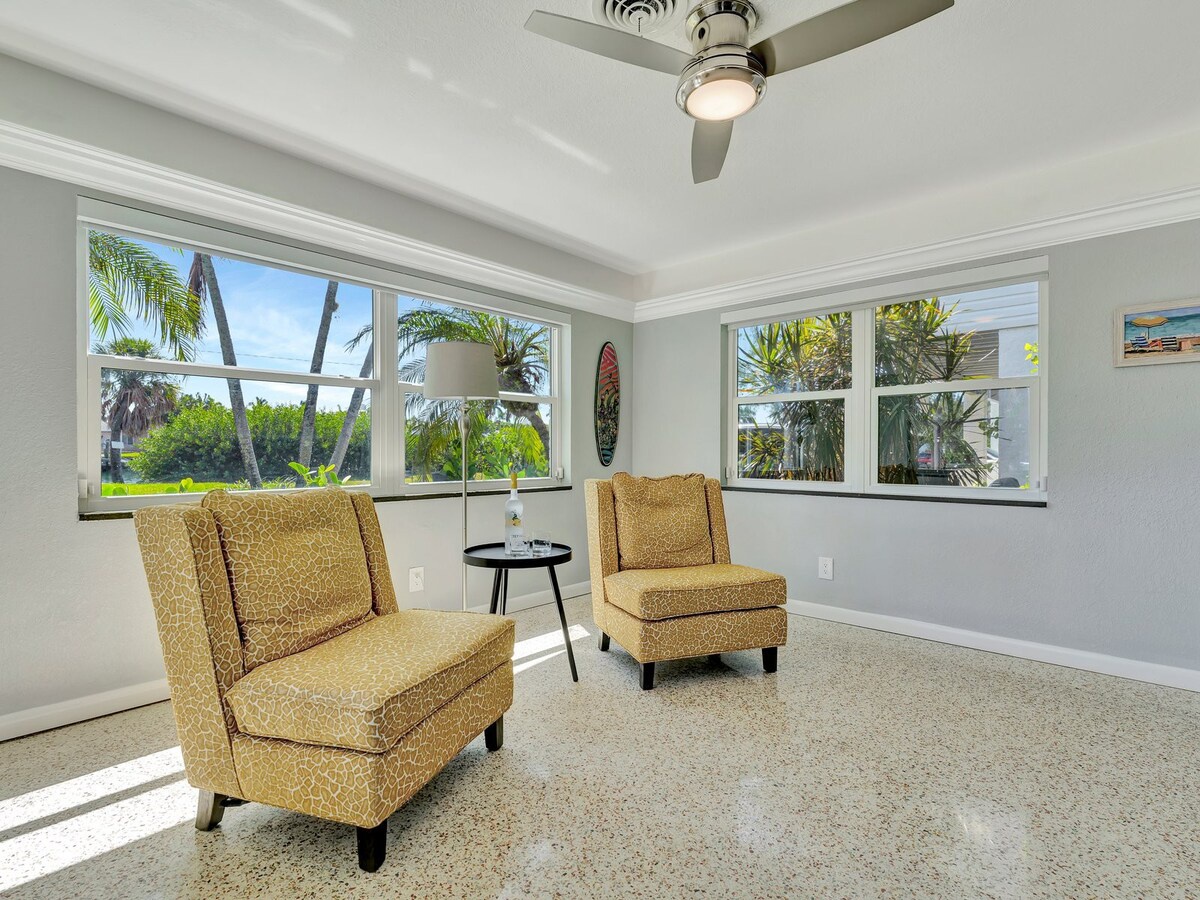 Settle into your cheerful sunroom with garden views, where two comfy chairs and a breezy ceiling fan invite you to relax with a book or morning coffee.
