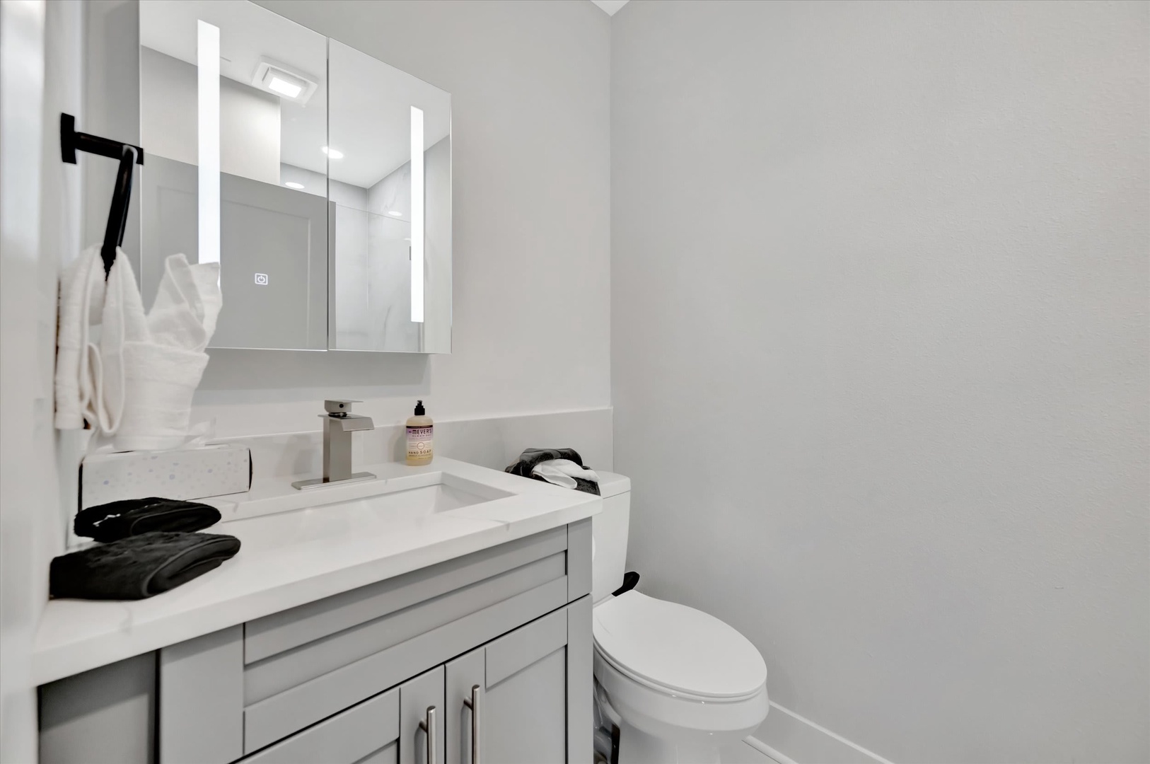 Step into a pristine bathroom where modern elegance meets comfort—crisp white surfaces and designer lighting frame your personal retreat.