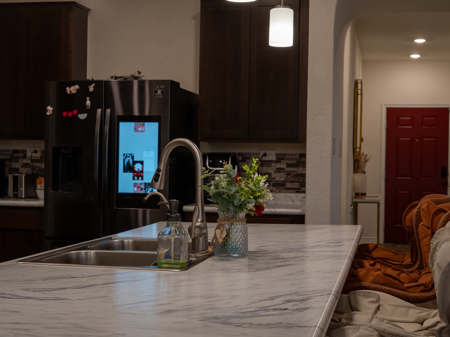 Step into your fully-equipped kitchen with sleek marble countertops, modern appliances, and thoughtful touches like fresh flowers to brighten your stay.