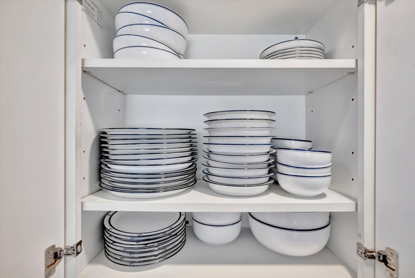 Open the cabinet to find everything you need to serve delicious home-cooked meals—neatly stacked plates, bowls, and dinnerware ready for your use.