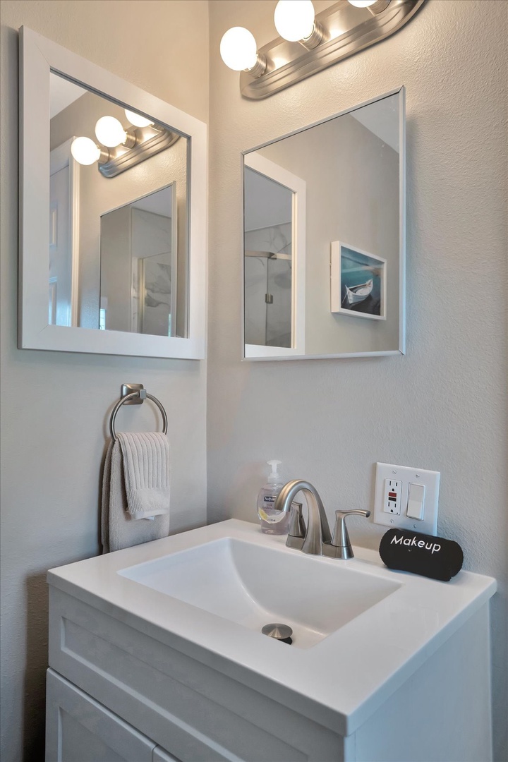 Your bright and modern bathroom features a sleek vanity with elegant fixtures, perfect lighting above the mirror, and thoughtful touches to help you feel fresh and ready for the day.