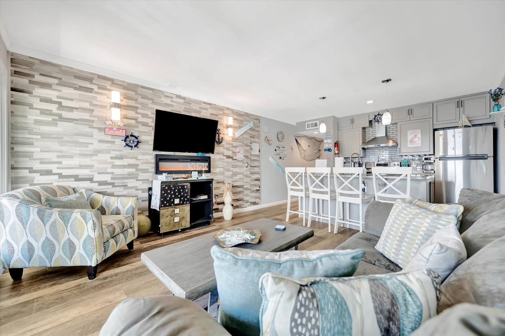 Sink into plush coastal-inspired seating where modern comfort meets beachy charm. Your open living space flows seamlessly into a fully-equipped kitchen, perfect for unwinding after sun-soaked days.