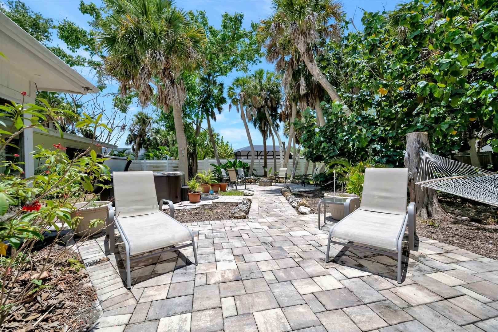 Sink into your lounge chair and let the tropical breeze drift through towering palms—your private oasis with hammock, hot tub, and shaded patio awaits just steps away.