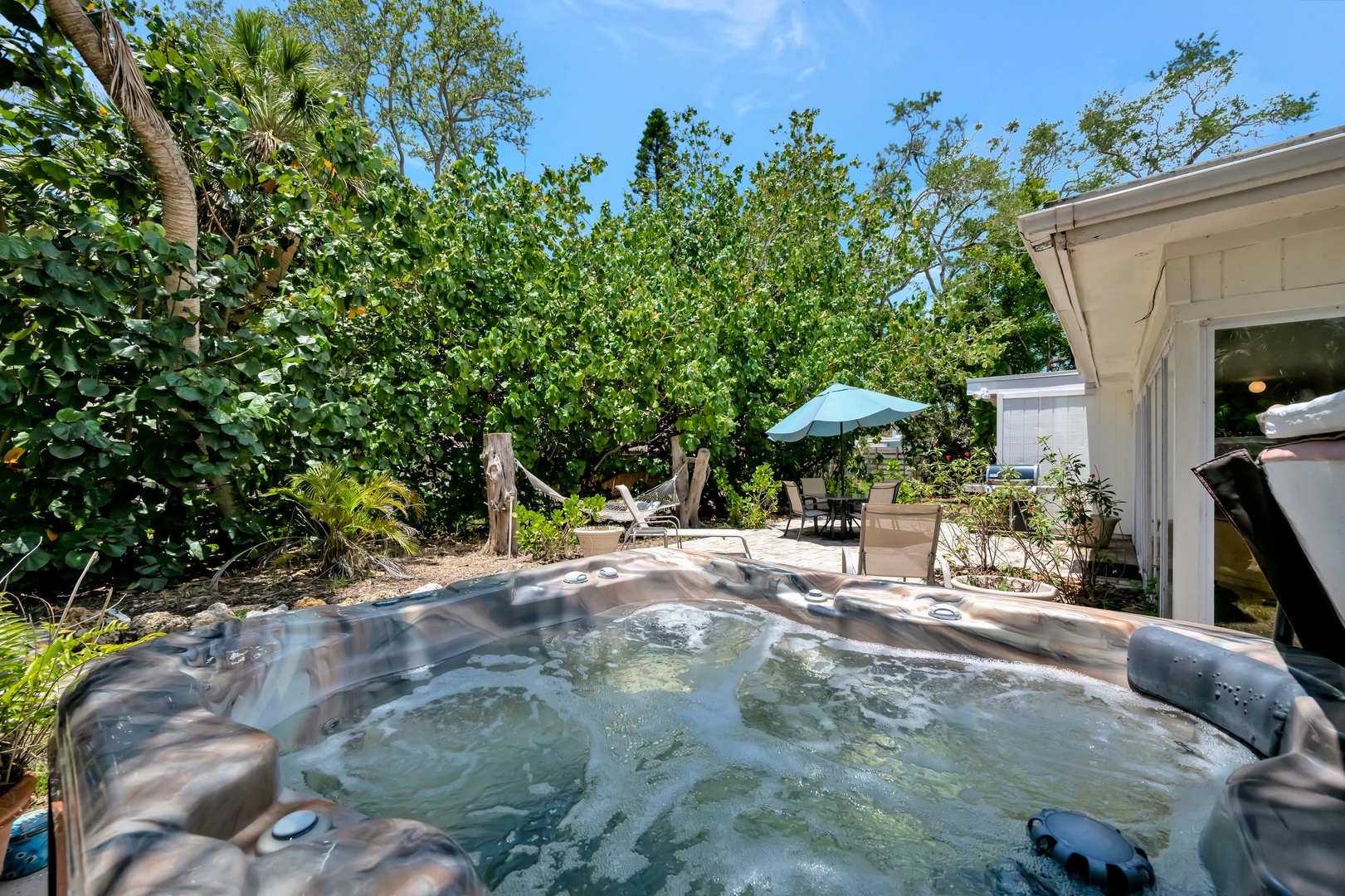 Unwind in your private hot tub surrounded by lush tropical gardens and sunshine—the perfect spot to soak away the day while enjoying the tranquil outdoor setting.
