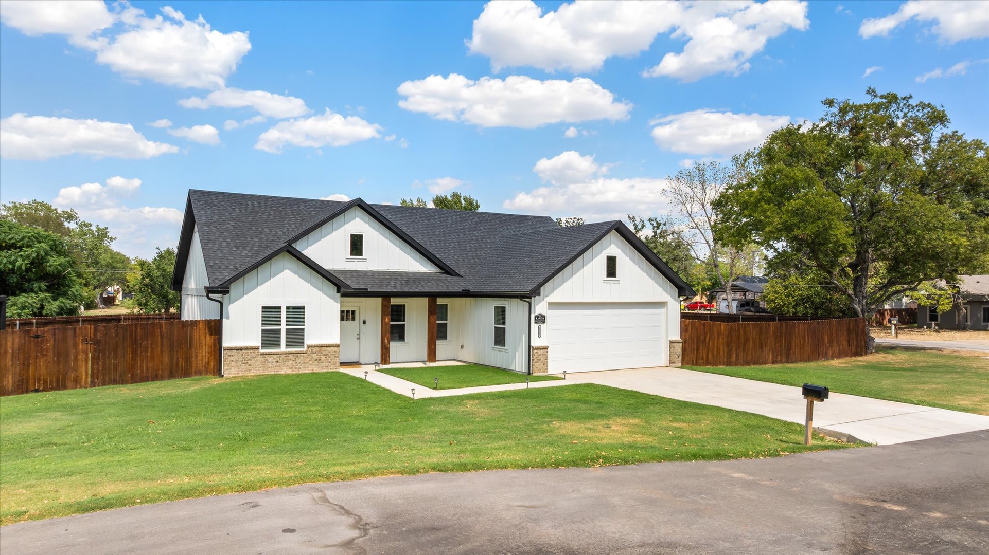 Modern ranch-style home set on a spacious corner lot with mature trees and fenced yard in a quiet residential neighborhood.