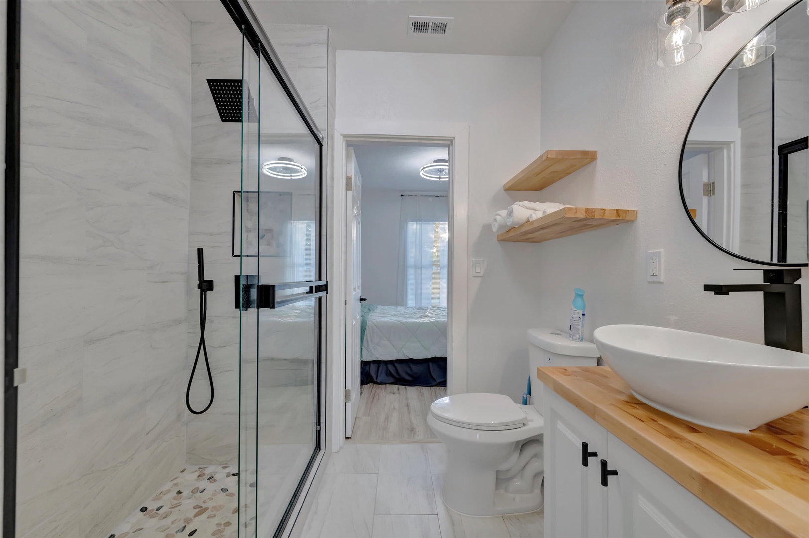 Your private bathroom features a modern walk-in shower, sleek fixtures, and warm wood accents that bring a spa-like feel to your stay.