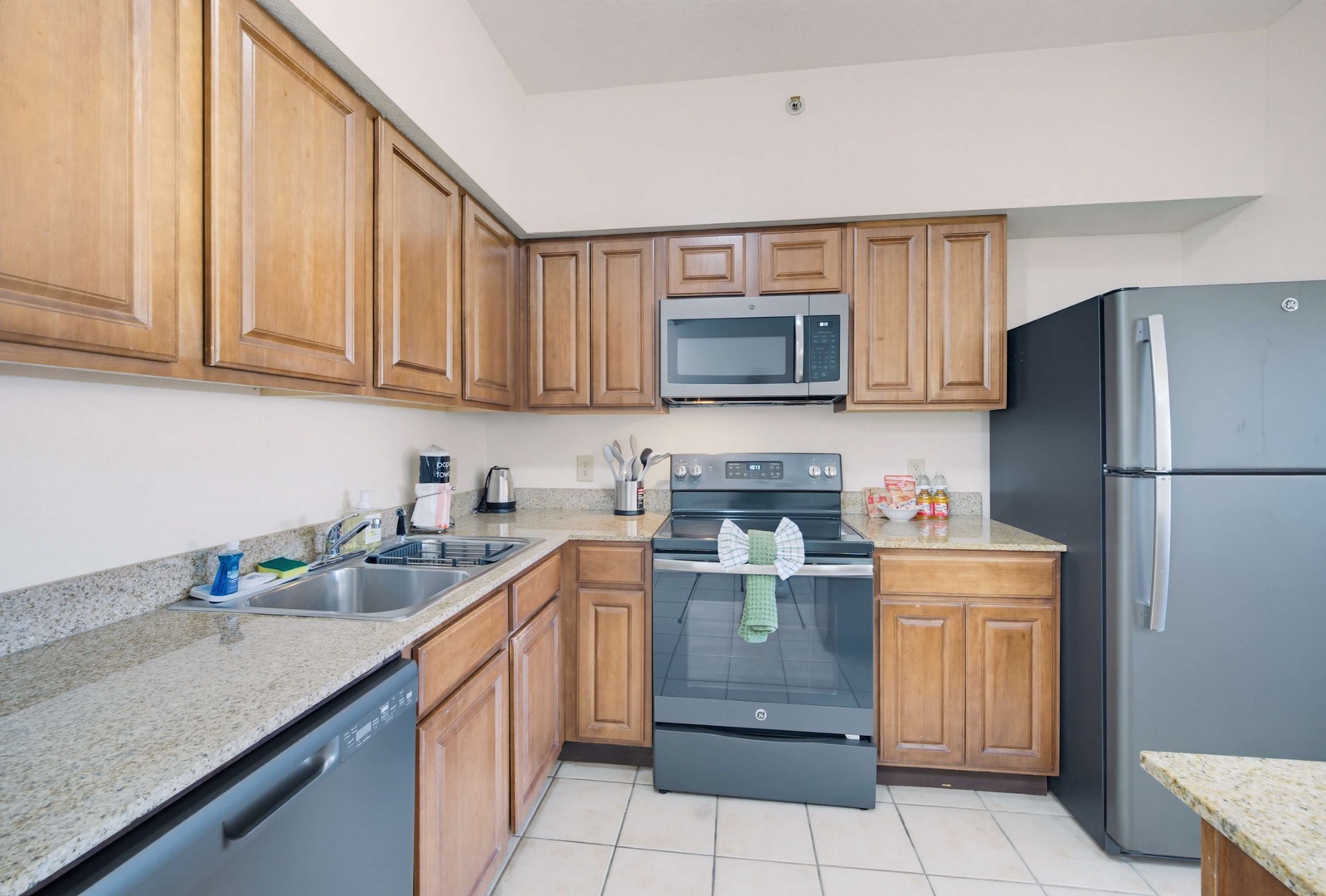 Your fully equipped kitchen awaits with modern stainless steel appliances, granite countertops, and warm wood cabinetry—everything you need to whip up a quick breakfast or family dinner in comfort.