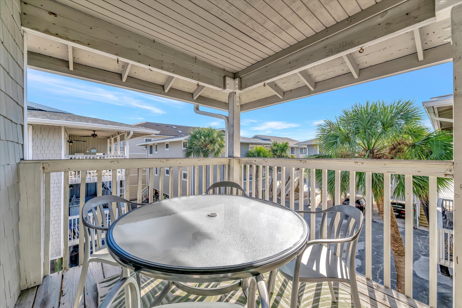 Step onto your private covered balcony and soak in the warm coastal breeze. Relax at the outdoor table, perfect for morning coffee or sunset cocktails with palm trees swaying nearby.