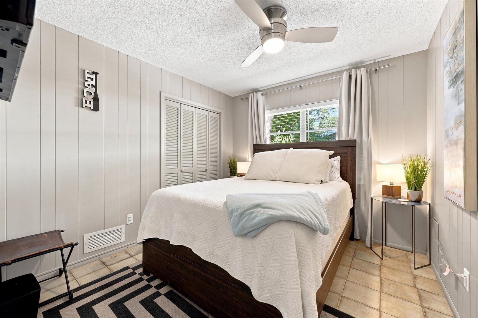 Sink into crisp white linens in your cozy bedroom, where natural light pours in and coastal charm wraps around you like a warm embrace.