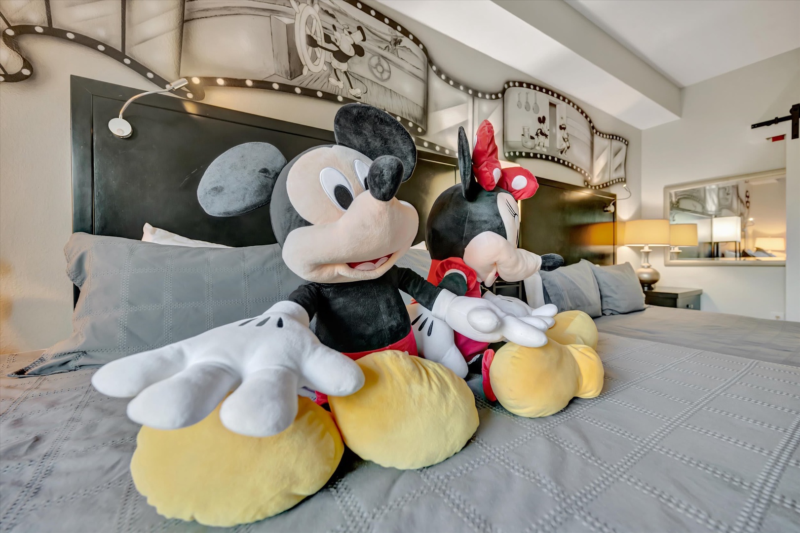 Your whimsical bedroom features a playful film-strip-inspired headboard with vintage Disney charm, complete with plush friends waiting to greet you after a magical day of adventures.