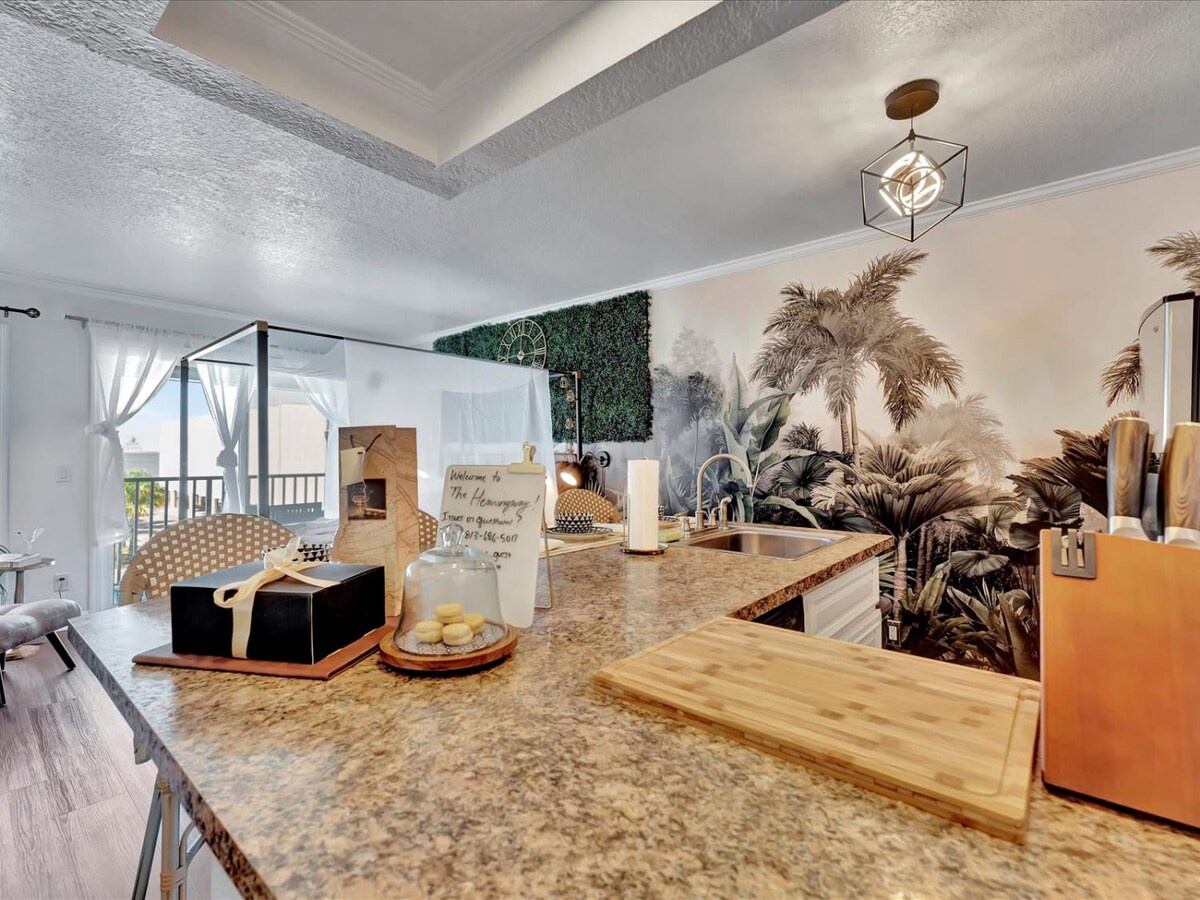 Your kitchen features granite countertops, modern appliances, and tropical-inspired décor that creates a warm, inviting space for preparing meals and gathering together.