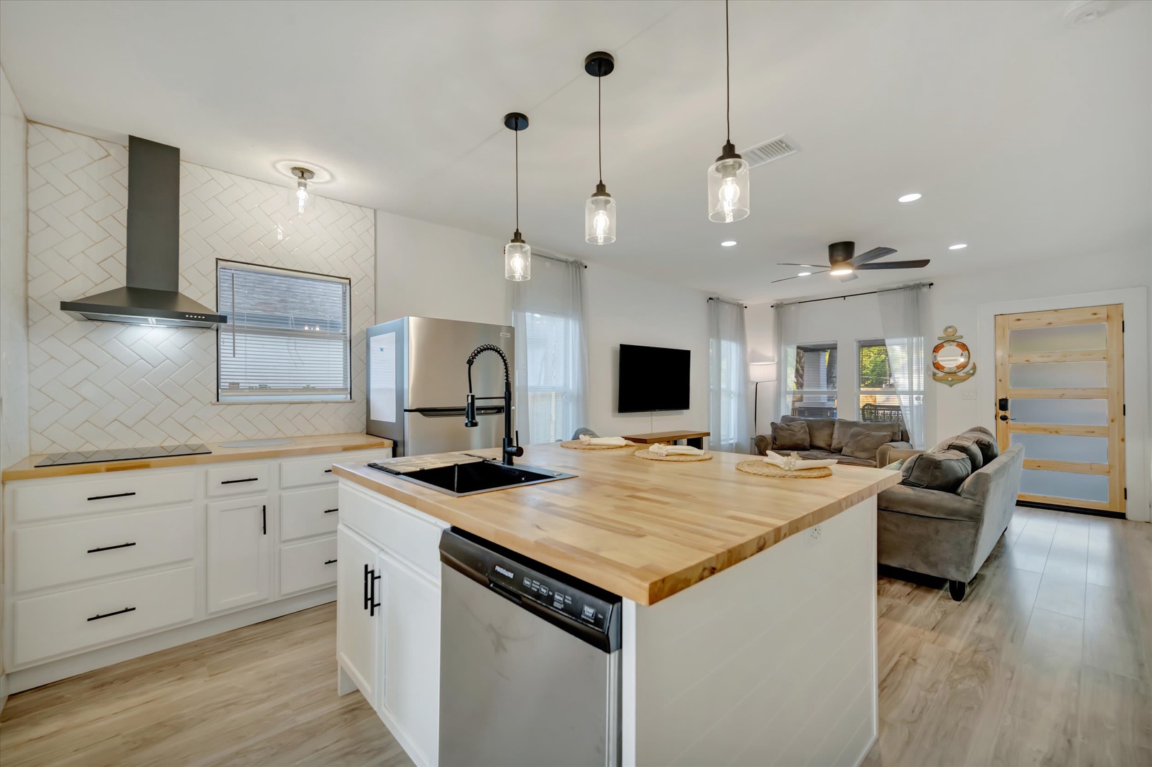 Step into your stylish open-concept retreat with a gleaming kitchen island perfect for meal prep and gathering. Natural light floods through bright windows, illuminating sleek countertops and cozy living spaces.