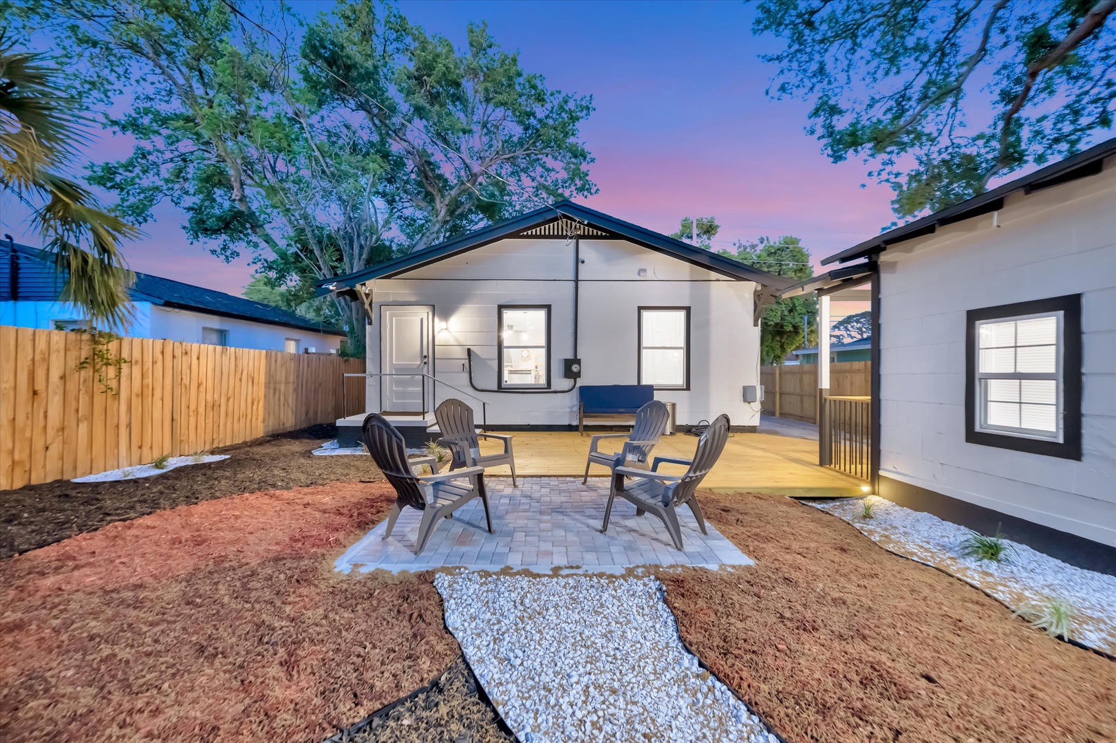 The property features a charming modern exterior with a private backyard patio, ideal for enjoying colorful evening skies and relaxed outdoor gatherings.