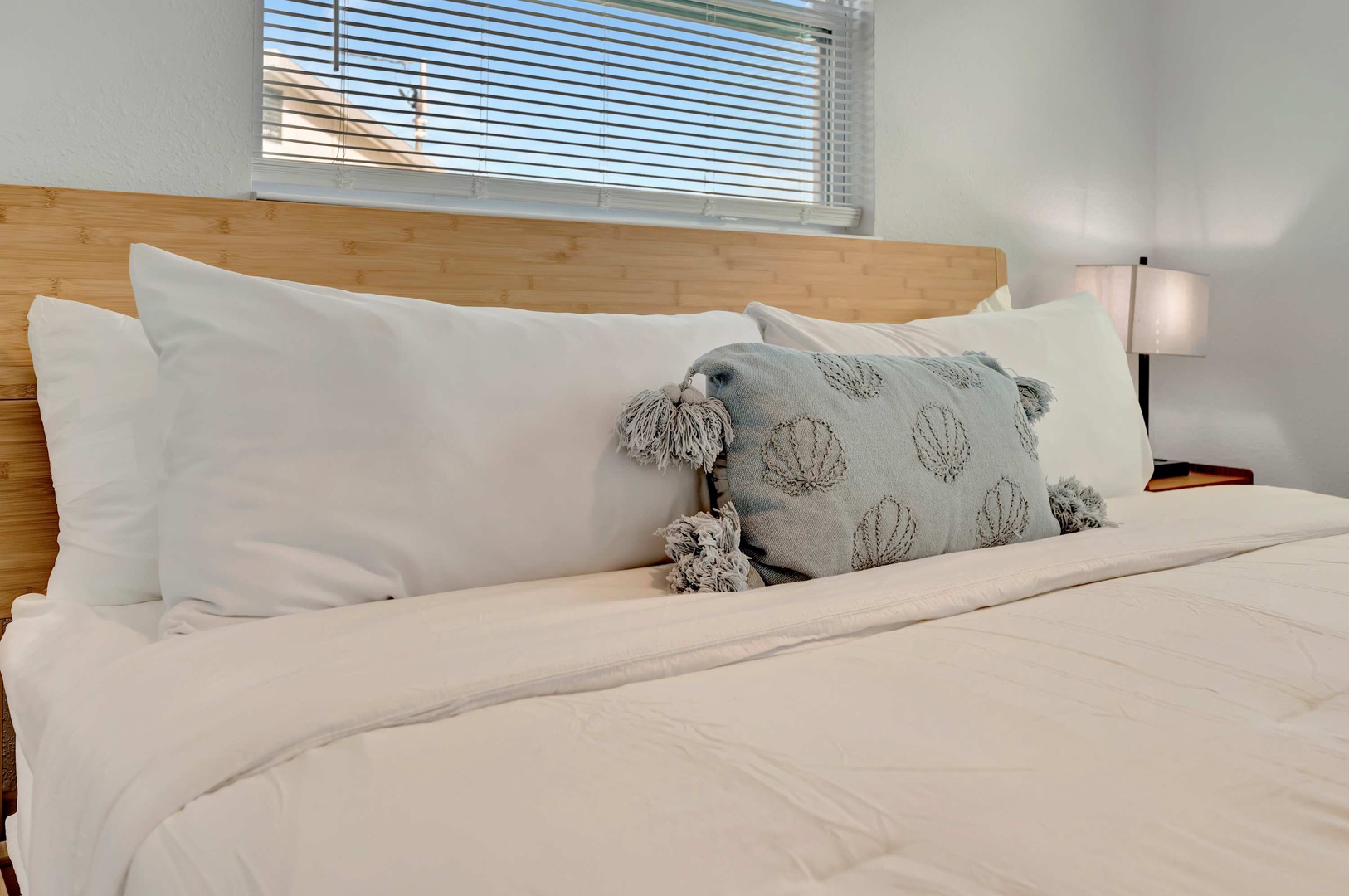 Sink into crisp linens and fluffy pillows on your cozy bed, with soft light filtering through the window for the perfect rest.