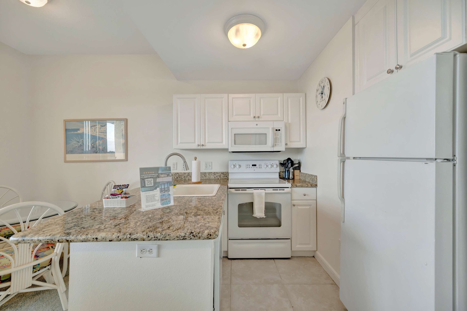 Your fully equipped kitchen awaits, ready for preparing quick breakfasts or leisurely meals. Granite countertops, modern appliances, and bright white cabinetry create a fresh, inviting space.