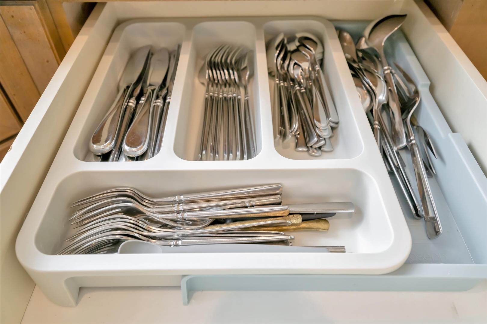 Your kitchen is stocked with polished silverware, neatly organized and ready for home-cooked meals or morning coffee at the table.