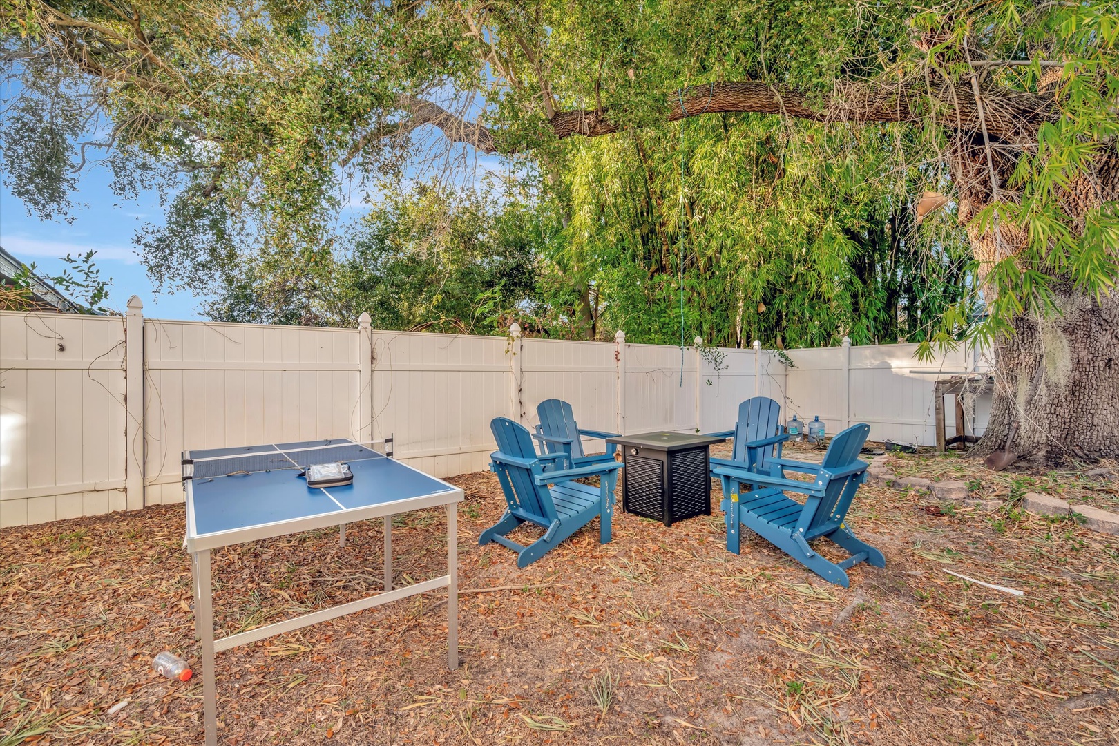 Gather around the fire pit in your private backyard, where Adirondack chairs and a ping-pong table set the stage for relaxed afternoons and fun evenings under swaying trees.