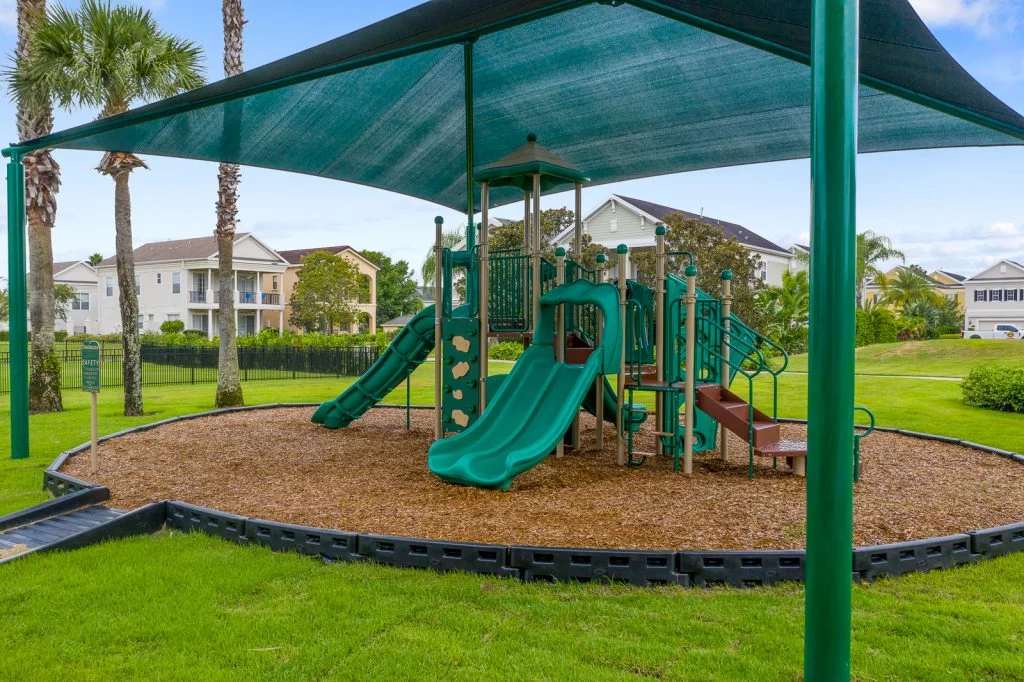 The community playground features slides, climbing structures, and shaded play areas—perfect for entertaining young guests while you relax nearby under the Florida sun.