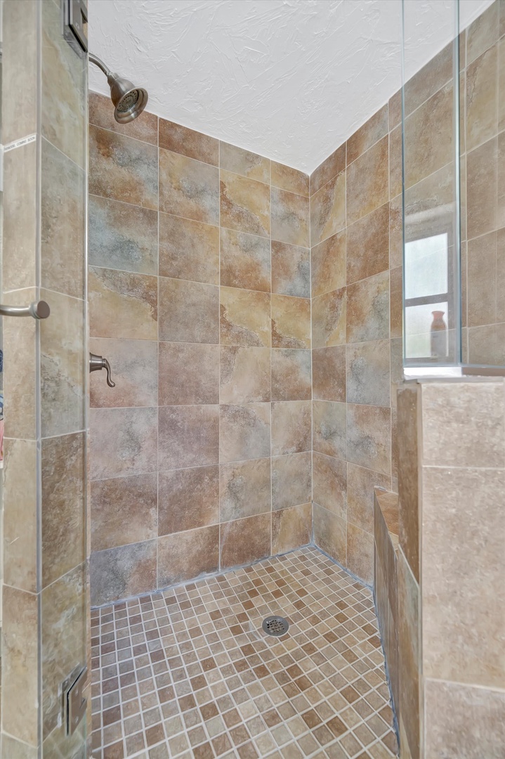 Your beautifully tiled walk-in shower features a rainfall showerhead and elegant earth-tone ceramic, creating a spa-like space to refresh and recharge each day.
